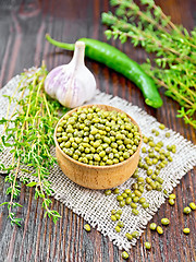 Image showing Mung beans in wooden bowl with thyme on board