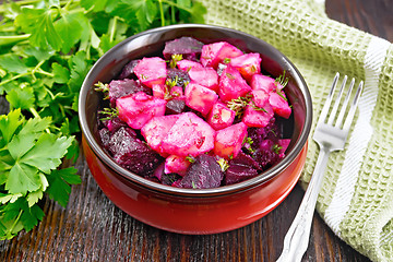 Image showing Salad of beets and potatoes with napkin in bowl on board