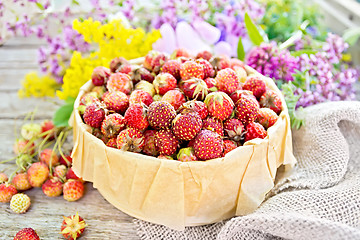 Image showing Strawberries in box with flowers on board