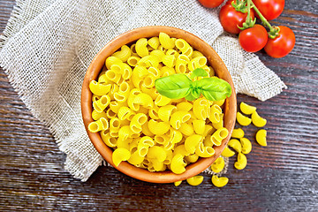 Image showing Elbow macaroni in bowl with tomatoes on dark board top