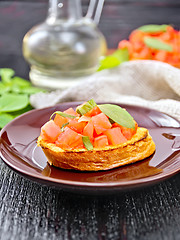 Image showing Bruschetta with tomato and basil in plate on dark board