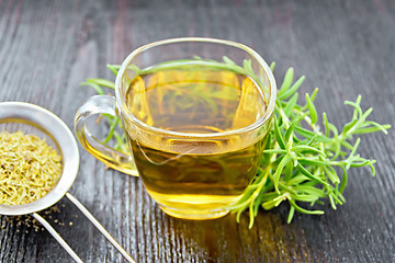 Image showing Tea of rosemary in cup with strainer on board