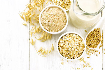 Image showing Oat flakes with flour and milk on light board top