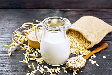 Image showing Milk oatmeal in jug on dark board