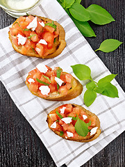 Image showing Bruschetta with tomato and feta on dark board top