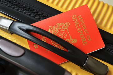 Image showing Singapore passport on a yellow suitcase