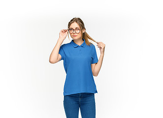 Image showing Closeup of young woman\'s body in empty blue t-shirt isolated on white background. Mock up for disign concept