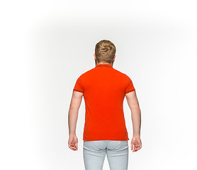 Image showing Closeup of young man\'s body in empty red t-shirt isolated on white background. Mock up for disign concept