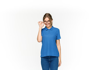 Image showing Closeup of young woman\'s body in empty blue t-shirt isolated on white background. Mock up for disign concept