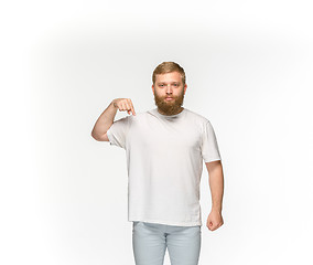 Image showing Closeup of young man\'s body in empty white t-shirt isolated on white background. Mock up for disign concept