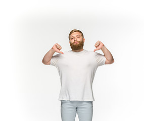 Image showing Closeup of young man\'s body in empty white t-shirt isolated on white background. Mock up for disign concept