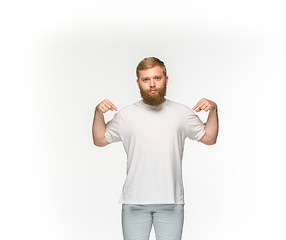 Image showing Closeup of young man\'s body in empty white t-shirt isolated on white background. Mock up for disign concept