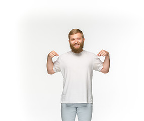 Image showing Closeup of young man\'s body in empty white t-shirt isolated on white background. Mock up for disign concept