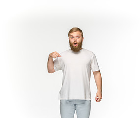 Image showing Closeup of young man\'s body in empty white t-shirt isolated on white background. Mock up for disign concept