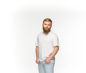 Image showing Closeup of young man\'s body in empty white t-shirt isolated on white background. Mock up for disign concept