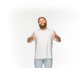 Image showing Closeup of young man\'s body in empty white t-shirt isolated on white background. Mock up for disign concept