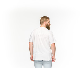 Image showing Closeup of young man\'s body in empty white t-shirt isolated on white background. Mock up for disign concept