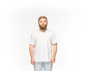 Image showing Closeup of young man\'s body in empty white t-shirt isolated on white background. Mock up for disign concept