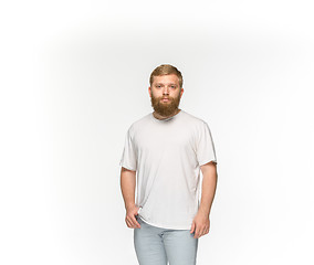 Image showing Closeup of young man\'s body in empty white t-shirt isolated on white background. Mock up for disign concept