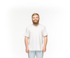 Image showing Closeup of young man\'s body in empty white t-shirt isolated on white background. Mock up for disign concept