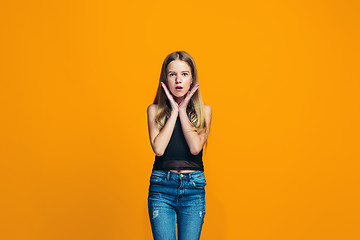 Image showing Beautiful teen girl looking suprised isolated on orange