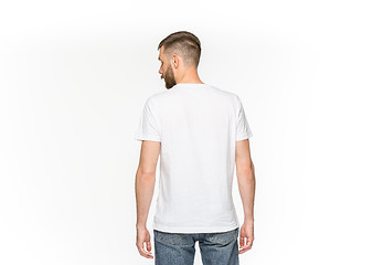 Image showing Closeup of young man\'s body in empty white t-shirt isolated on white background. Mock up for disign concept