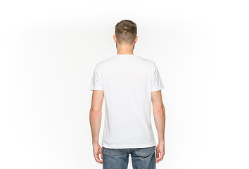 Image showing Closeup of young man\'s body in empty white t-shirt isolated on white background. Mock up for disign concept