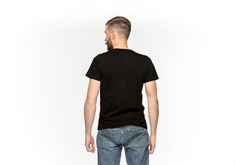 Image showing Closeup of young man\'s body in empty black t-shirt isolated on white background. Mock up for disign concept