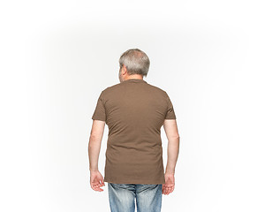 Image showing Closeup of senior man\'s body in empty brown t-shirt isolated on white background. Mock up for disign concept