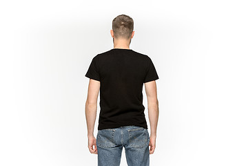 Image showing Closeup of young man\'s body in empty black t-shirt isolated on white background. Mock up for disign concept