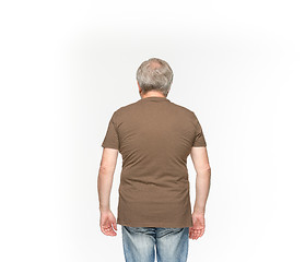 Image showing Closeup of senior man\'s body in empty brown t-shirt isolated on white background. Mock up for disign concept