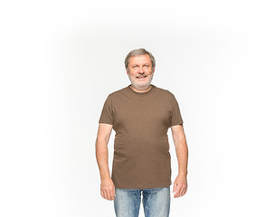 Image showing Closeup of senior man\'s body in empty brown t-shirt isolated on white background. Mock up for disign concept