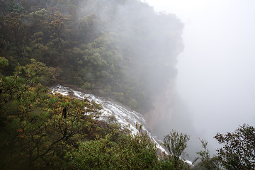 Image showing Waterfall flows off the cliff into the foggy abyss