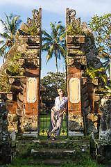 Image showing Young blonde caucasian woman traveling and exploring traditional hidu tamples around Ubud on Bali.