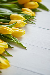 Image showing Composition of fresh tulips placed in row on white rustic wooden table