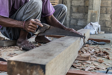 Image showing Close up of warn hands of carpenter working in traditional manual carpentry shop in a third world country.