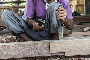 Image showing Close up of warn hands of carpenter working in traditional manual carpentry shop in a third world country.