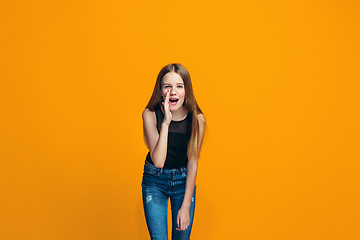 Image showing Isolated on yellow young casual teen girl shouting at studio