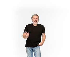 Image showing Closeup of senior man\'s body in empty black t-shirt isolated on white background. Mock up for disign concept