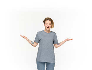 Image showing Closeup of young woman\'s body in empty gray t-shirt isolated on white background. Mock up for disign concept