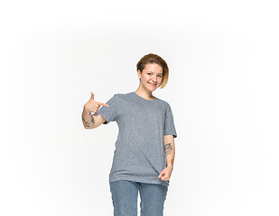 Image showing Closeup of young woman\'s body in empty gray t-shirt isolated on white background. Mock up for disign concept