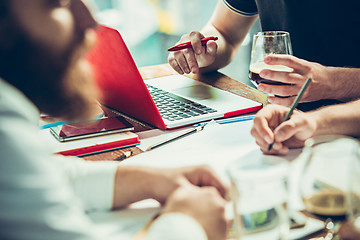 Image showing The hands of people working and relaxing in pub.