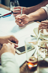 Image showing The hands of people working and relaxing in pub.