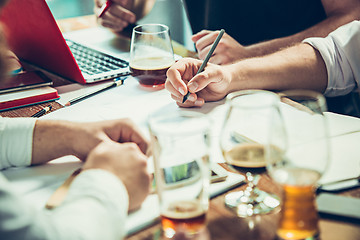 Image showing The hands of people working and relaxing in pub.