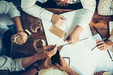 Image showing The hands of people working and relaxing in pub.