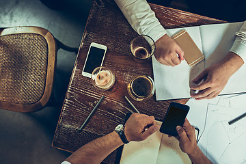 Image showing The hands of people working and relaxing in pub.