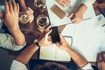 Image showing The hands of people working and relaxing in pub.