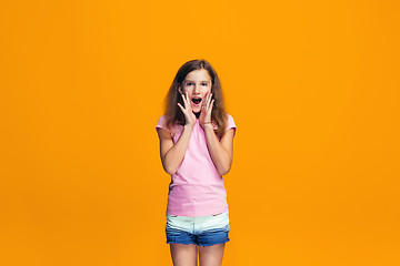 Image showing Isolated on yellow young casual teen girl shouting at studio