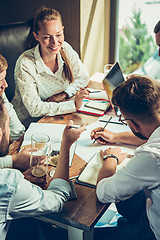 Image showing Young cheerful people smile and gesture while relaxing in pub.