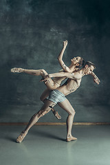 Image showing The young modern ballet dancers posing on gray studio background